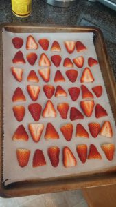 Strawberries cut on a baking sheet