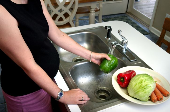 pregnant woman washing produce