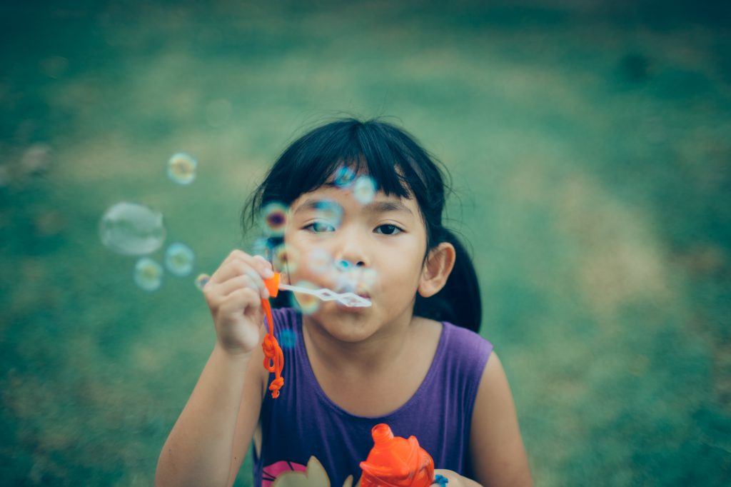 young girl blowing bubbles