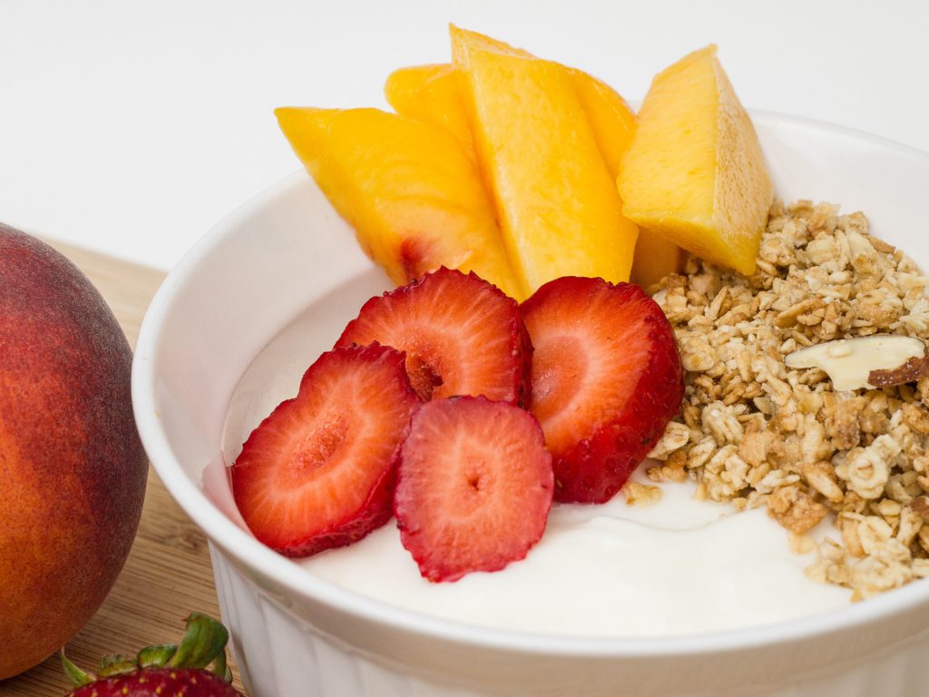 yogurt with strawberries, peaches and granola