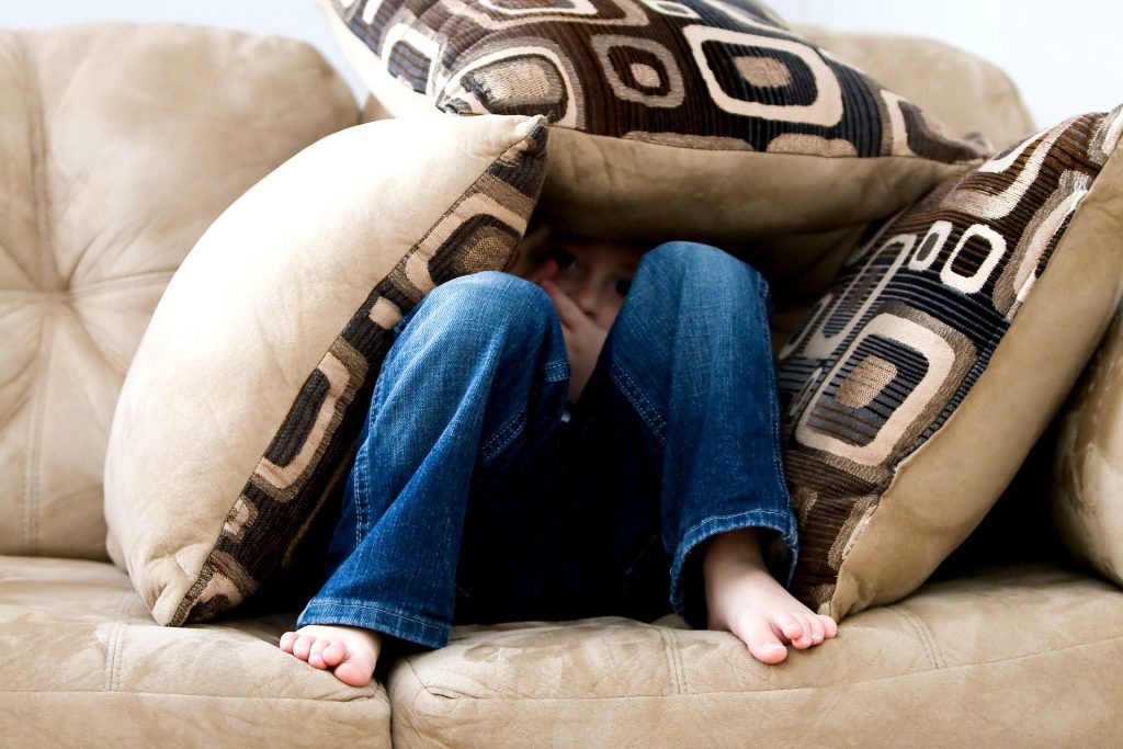 kid hiding in pillow fort 