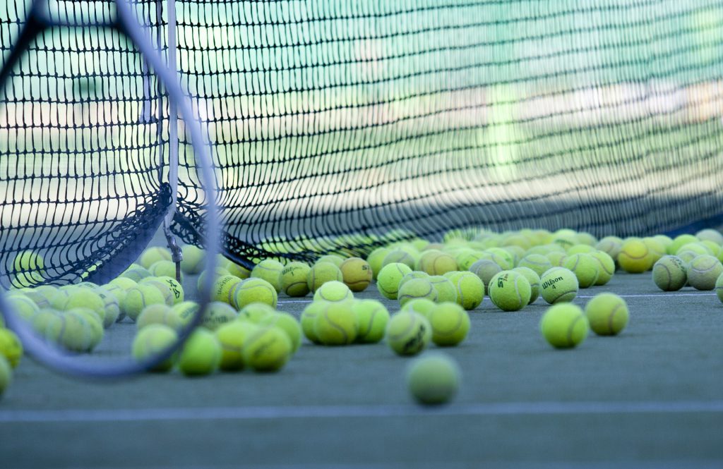 tennis balls near tennis net 