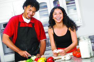 two people cooking in a kitchen